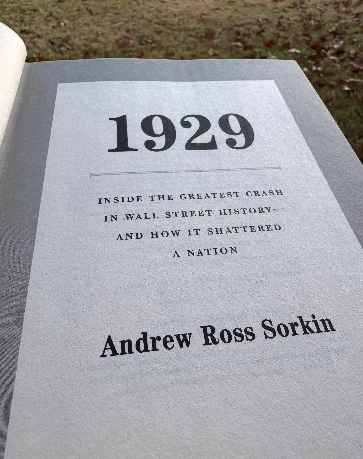 Title page of 1929 by Andrew Ross Sorkin, held open outside
