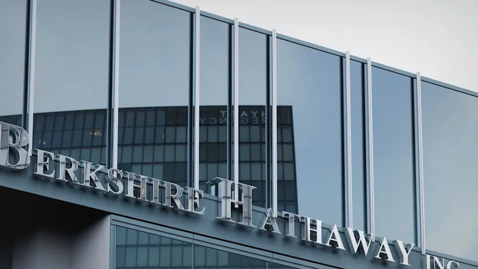 The Berkshire Hathaway Inc. sign in silver letters on a glass office building