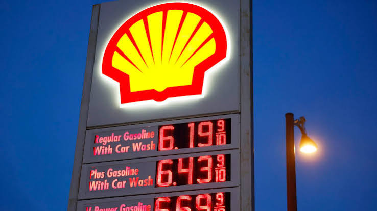A lit Shell station sign at dusk showing regular gasoline at $6.19 and plus gasoline at $6.43 a gallon