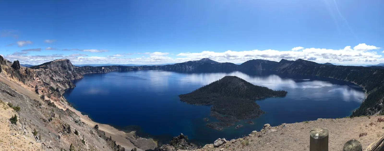 Panorama of Crater Lake in Oregon, with deep blue water, Wizard Island and the surrounding crater rim