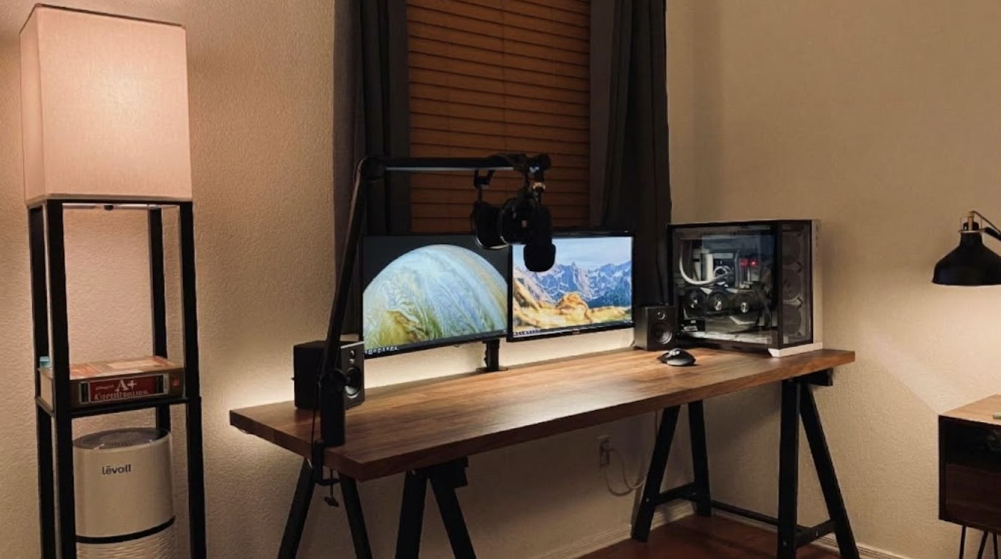 Desk setup with two monitors, a boom-arm microphone, speakers and a desktop computer