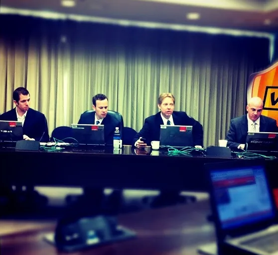 Keith Brown and three colleagues seated at a leadership meeting during his Superpages.com years